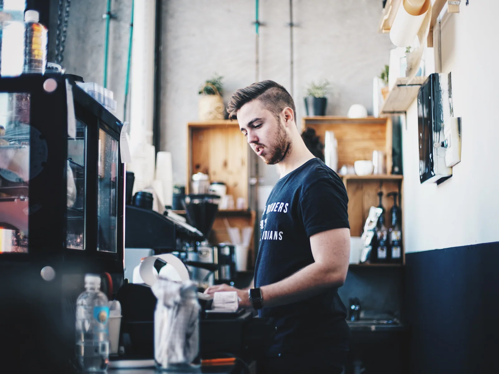 A barista working behind the counter of a neighborhood café